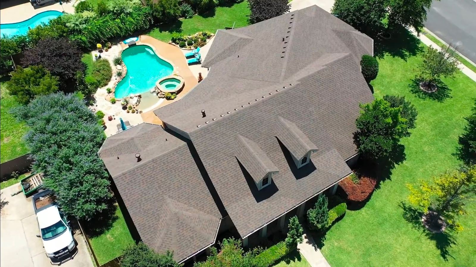 Top-down aerial view of a completed shingle roof with dormers