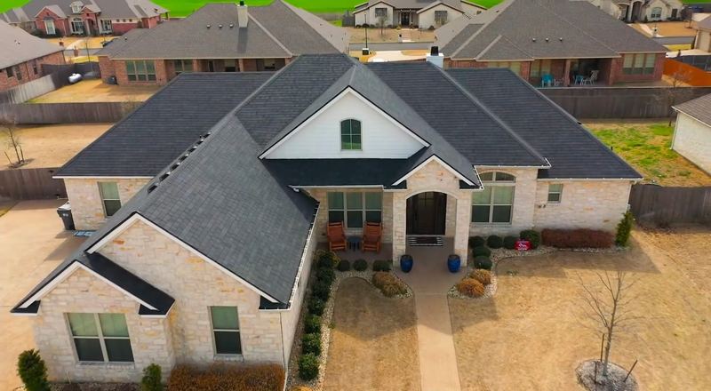 Completed shingle roof replacement on a stone home in Central Texas